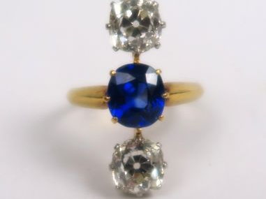 Bague ornée en ligne de deux diamants taille coussin et d'un saphir au