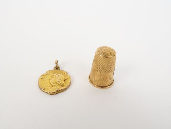 Un dé et une médaille religieuse en or. 7 g