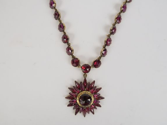 Collier or et pendentif en forme d'étoile orné de grenats. Poids tel :