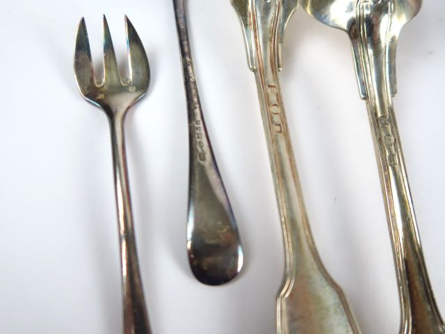 12 couverts en argent étranger, modèle au filet. Chiffrés. On y joint 
