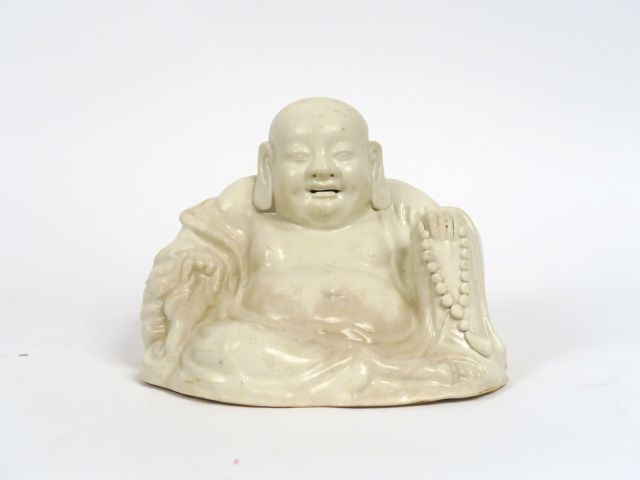 Bouddha assis sur un sac des richesses en porcelaine blanc de Chine. C