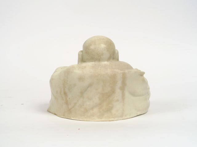 Bouddha assis sur un sac des richesses en porcelaine blanc de Chine. C