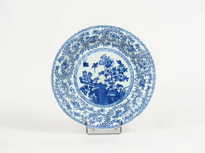 Plat à bords festonnés, en porcelaine médaillon central à décor d'oise