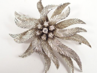 Vente aux enchères Broche en or blanc en forme de fleur épanouie, rehaussée en son centre