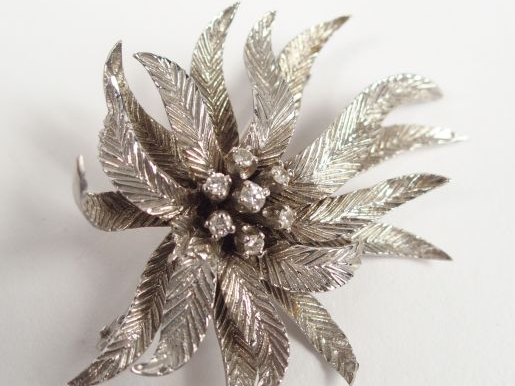 Broche en or blanc en forme de fleur épanouie, rehaussée en son centre