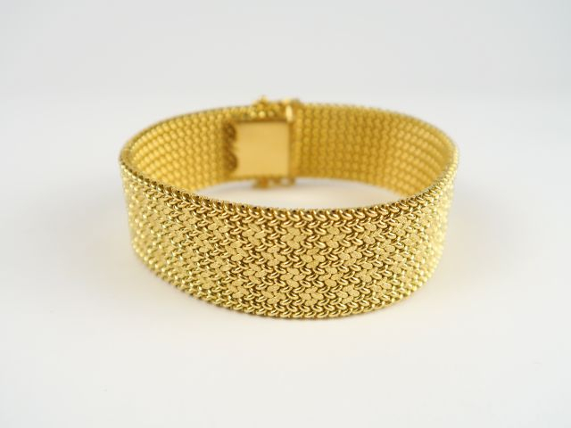 Bracelet maille souple en or, à décor de fleurs stylisées. Poids : 42,
