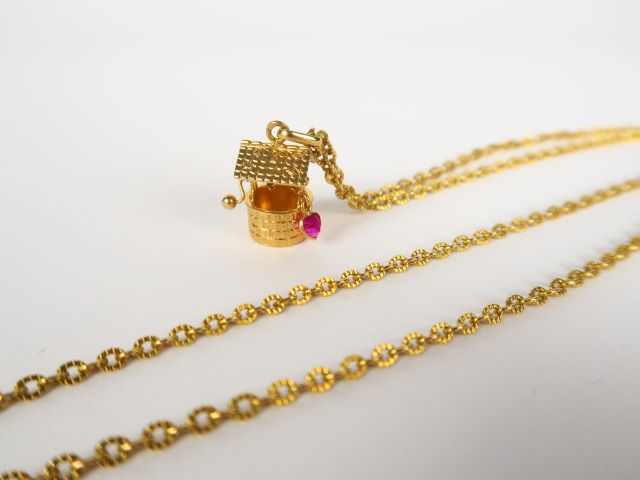 Chaine en or et son pendentif figurant un puits, orné d'une petite pie