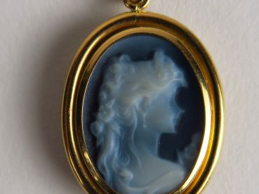 Pendentif à décor d'un profil de jeune femme, monture en or. Poids tel