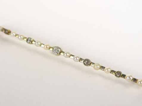 Broche en or blanc, sertie en alternance de perles (une changée), et d