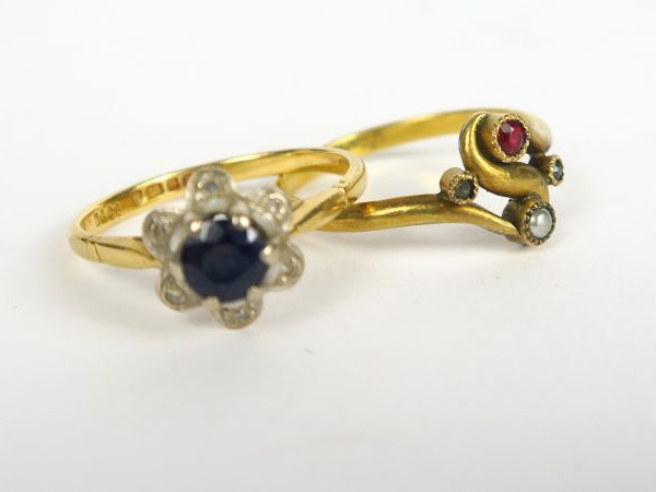 Bague ornée d'un saphir dans un entourage de roses. Monture en or. On 