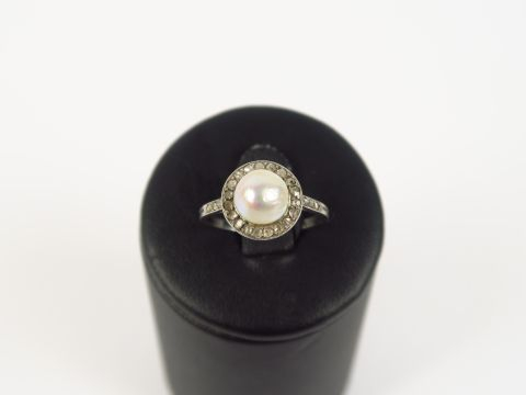 Bague 1900 en or blanc ornée d'une perle entourée de roses.  3 g