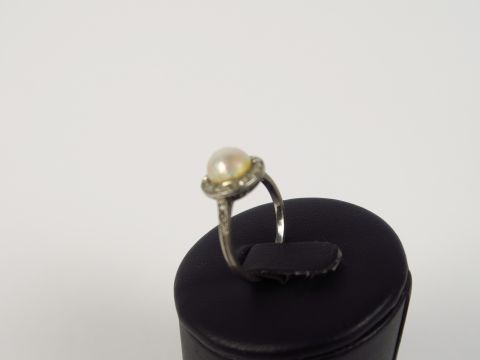Bague 1900 en or blanc ornée d'une perle entourée de roses.  3 g