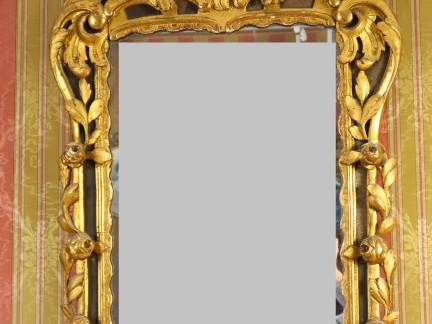 Glace Louis XV en bois sculpté et doré, à décor de roses, de feuilles 