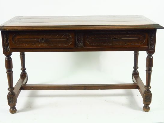 Bureau plat de style Henri II en noyer mouluré et sculpté, ouvrant à d