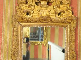 Glace Louis XV en bois sculpté et doré, à décor de rocailles et de feu