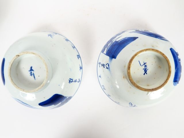 Bouteille en céramique bleu sur fond crème, décor de paysage lacustre.