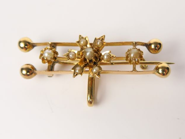 Broche en or jaune ornée de petites perles à décor floral. Poids tel :