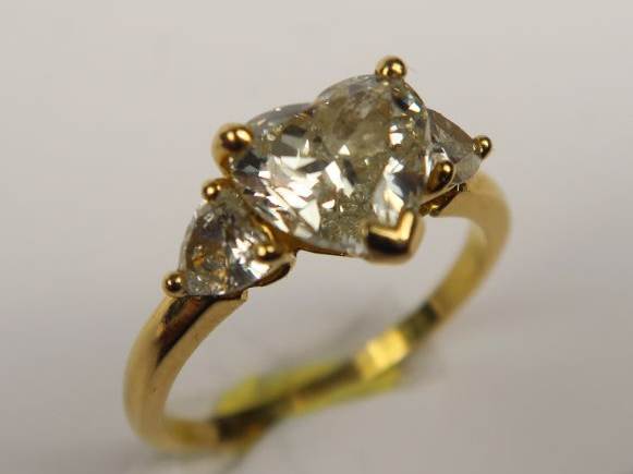 Bague ornée d'un brillant taillé en coeur, épaulé de brillants plus pe