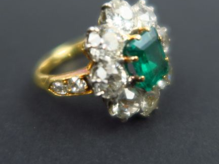 Bague marguerite sertie d'une émeraude et de huit diamants taille anci