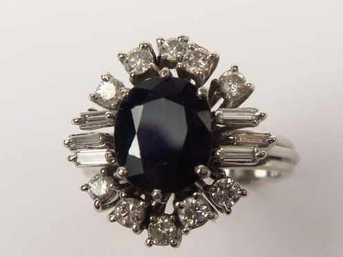 Bague marguerite en or gris ornée d’un saphir entouré de diamants bril