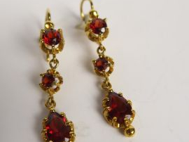 Paire de boucles d’oreilles en or jaune à chute de trois grenats. Poid