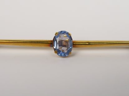 Broche barrette en or jaune ornée d’une pierre de couleur. Poids tel :