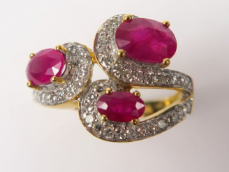 Vente aux enchères Bague ornée de trois rubis, soulignés par des lignes de diamants. Mont