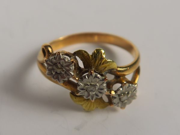 Bague en or figurant trois fleurs ornées de roses