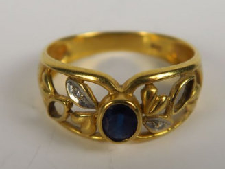Vente aux enchères Bague en or sertie d'un saphir, monture ajourée à motif de feuillage. 