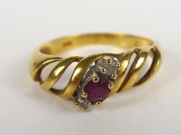 Bague en or ajourée sertie d'un rubis, et de deux petits diamants. Poi