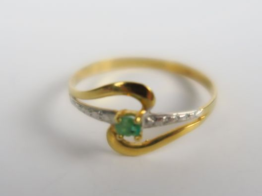 Bague en or, monture ajourée sertie d'une petite émeraude.