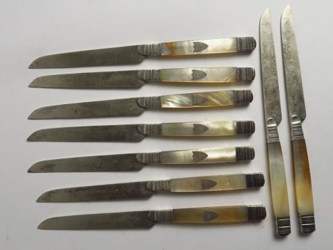 Suite de neuf couteaux à fruits manche en nacre orné d'un cartouche, l