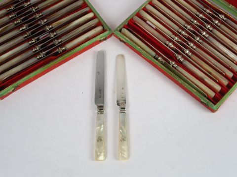 Dans deux écrins : 18 couteaux lame argent, manche en nacre, et 18 aut