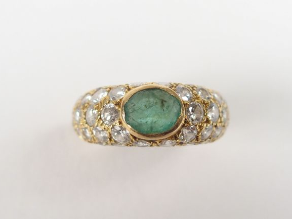 Bague moderne monture or jaune, sertie en son centre d'une émeraude et