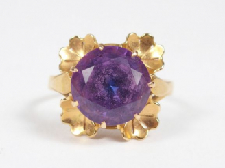 Vente aux enchères Bague monture or jaune ornée d’un corindon synthétique violet entourag