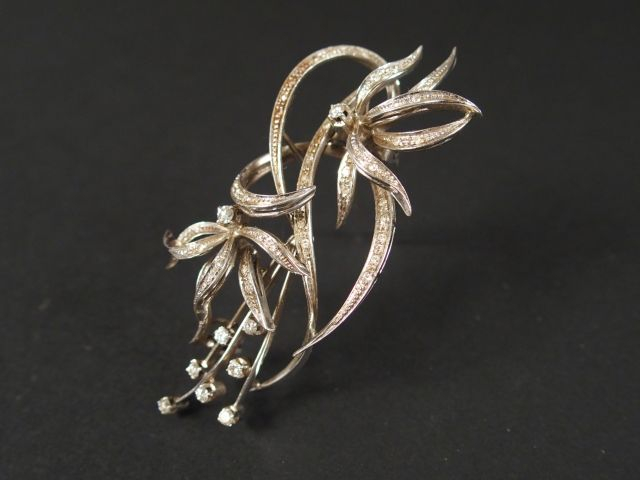 Broche monture platine en forme de branche fleurie stylisée, pavée de 