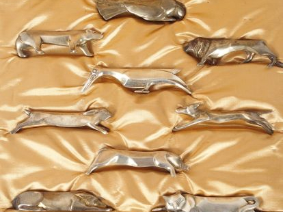 GALLIA. Suite de 12 porte-couteaux d'après Benjamin Rabier en métal ar