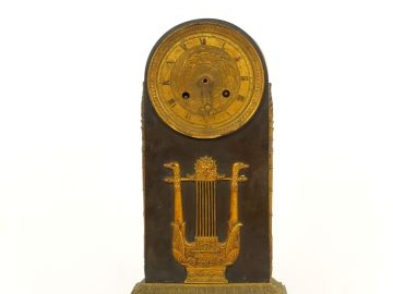 Pendule borne Restauration en tôle et bronze doré, à décor de lyre, de
