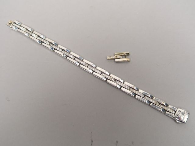 Bracelet articulé en or blanc, orné d'une ligne de brillants. On y joi