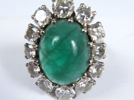 Bague marguerite ornée d'une émeraude en cabochon, dans un entourage d