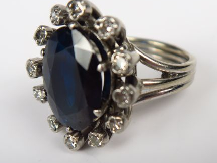 Bague en or, ornée d'un saphir dans un entourage de brillants sertis c