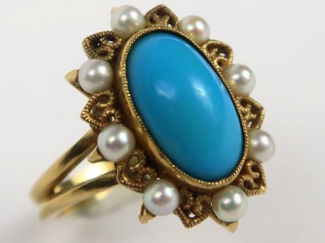 Bague en or, ornée d'une turquoise dans un entourage de perles. Poids 
