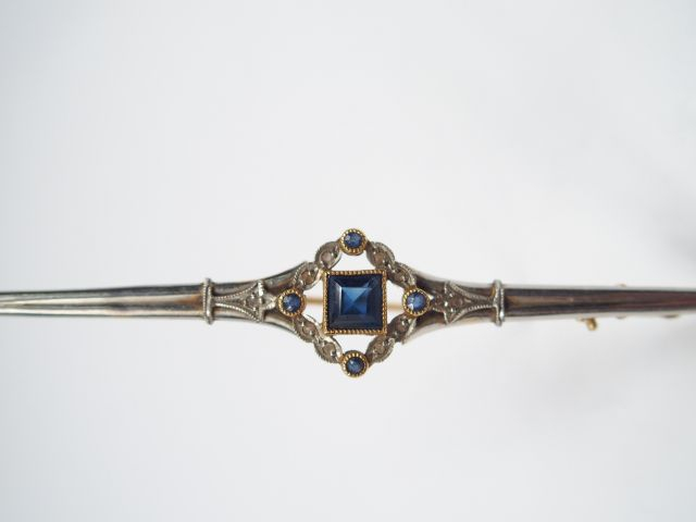 Broche Art Déco en or jaune et blanc, ornée d'un saphir central entour