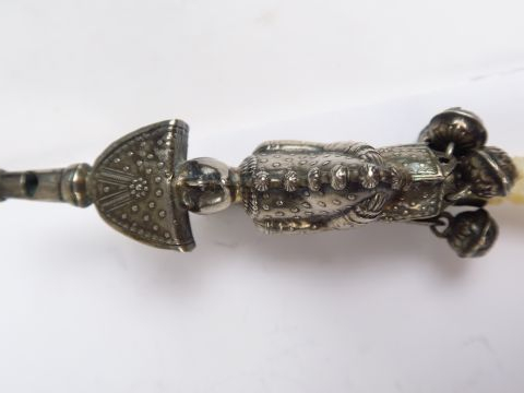 Hochet siffleur XIXe en argent, figurant polichinelle. Retenant quatre