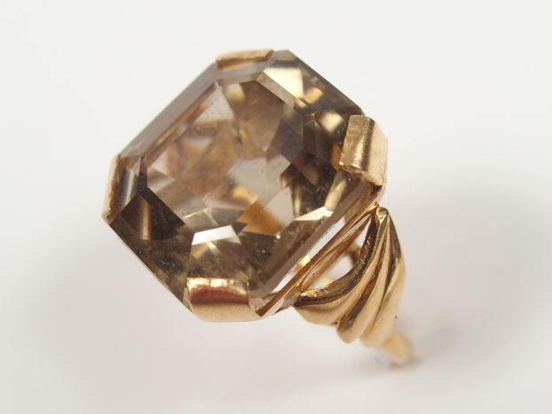 Bague en or jaune, monture travaillée, ornée d'un quartz brun taille r