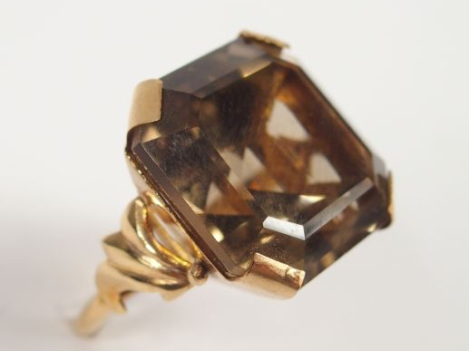 Bague en or jaune, monture travaillée, ornée d'un quartz brun taille r