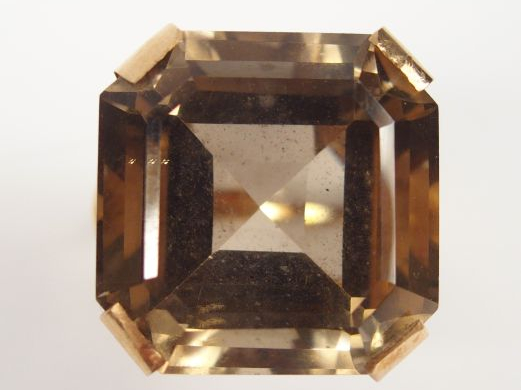 Bague en or jaune, monture travaillée, ornée d'un quartz brun taille r