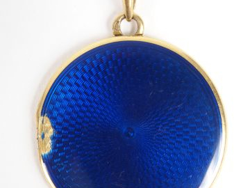 Pendentif porte-photo monture or jaune, émail bleu (sauts). Diam. : 24