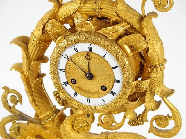 Pendule Restauration en bronze ciselé et doré, en forme de fleur et de