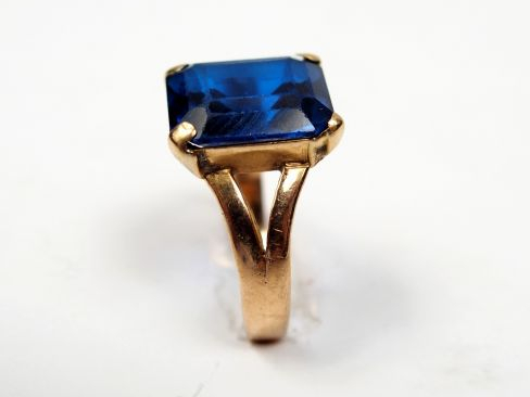 Bague en or jaune, ornée d'un saphir synthétique taille émeraude. TDD 